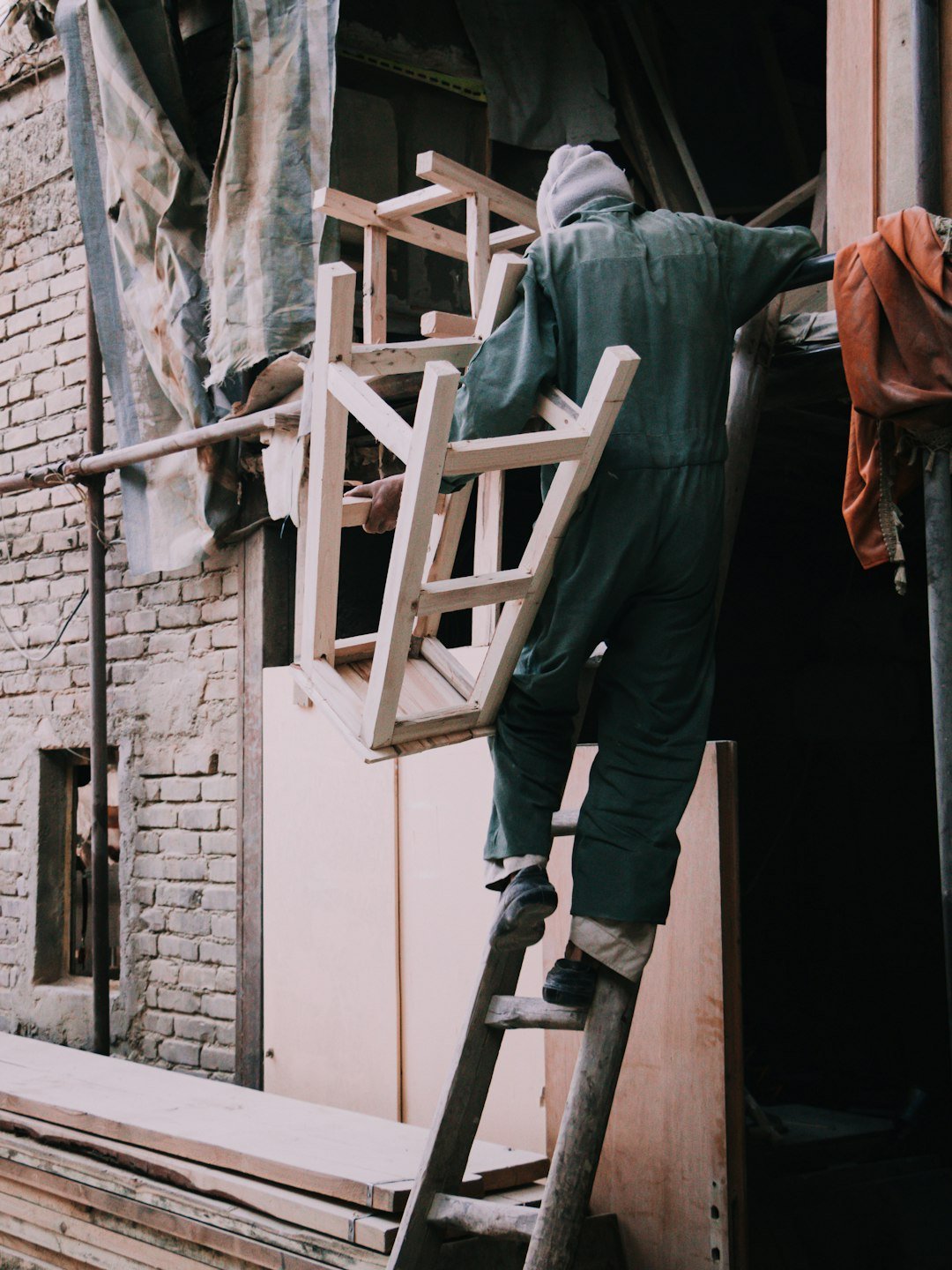 about-me-01 a-man-in-a-green-coverall-climbing-up-a-ladder-hcf49d2fjju