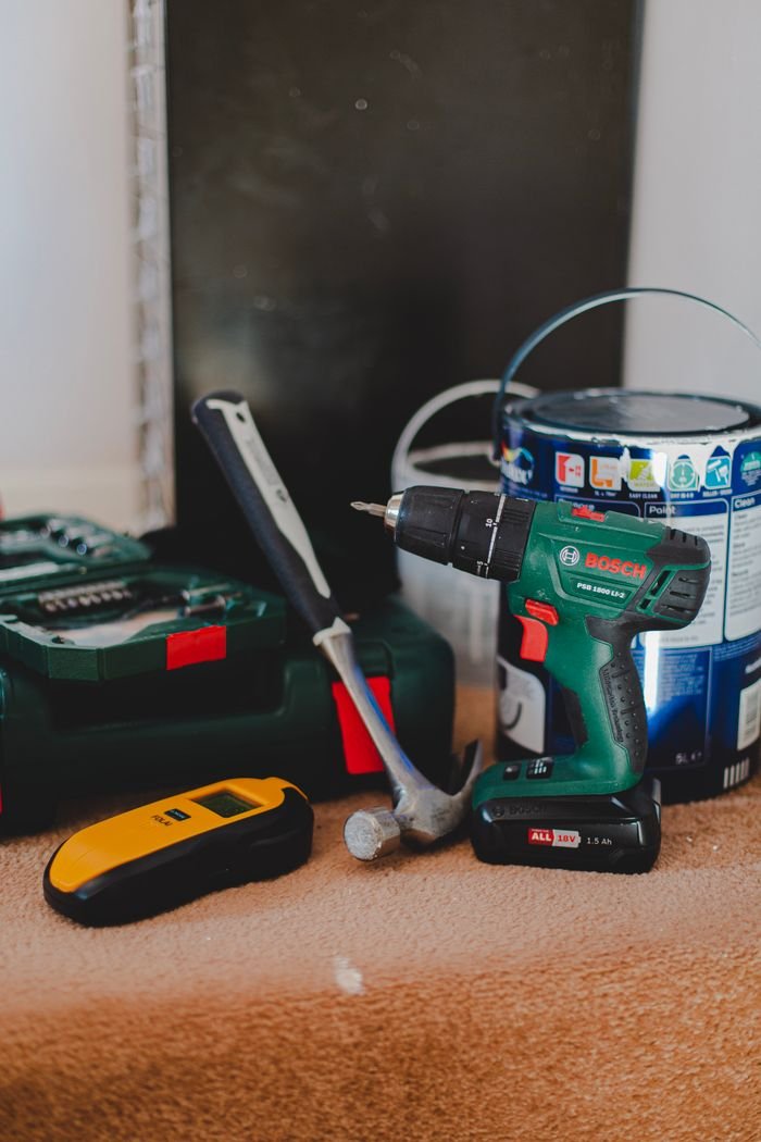 featured-images-02 A selection of essential tools for home improvement projects, featuring a drill, hammer, and paint supplies.