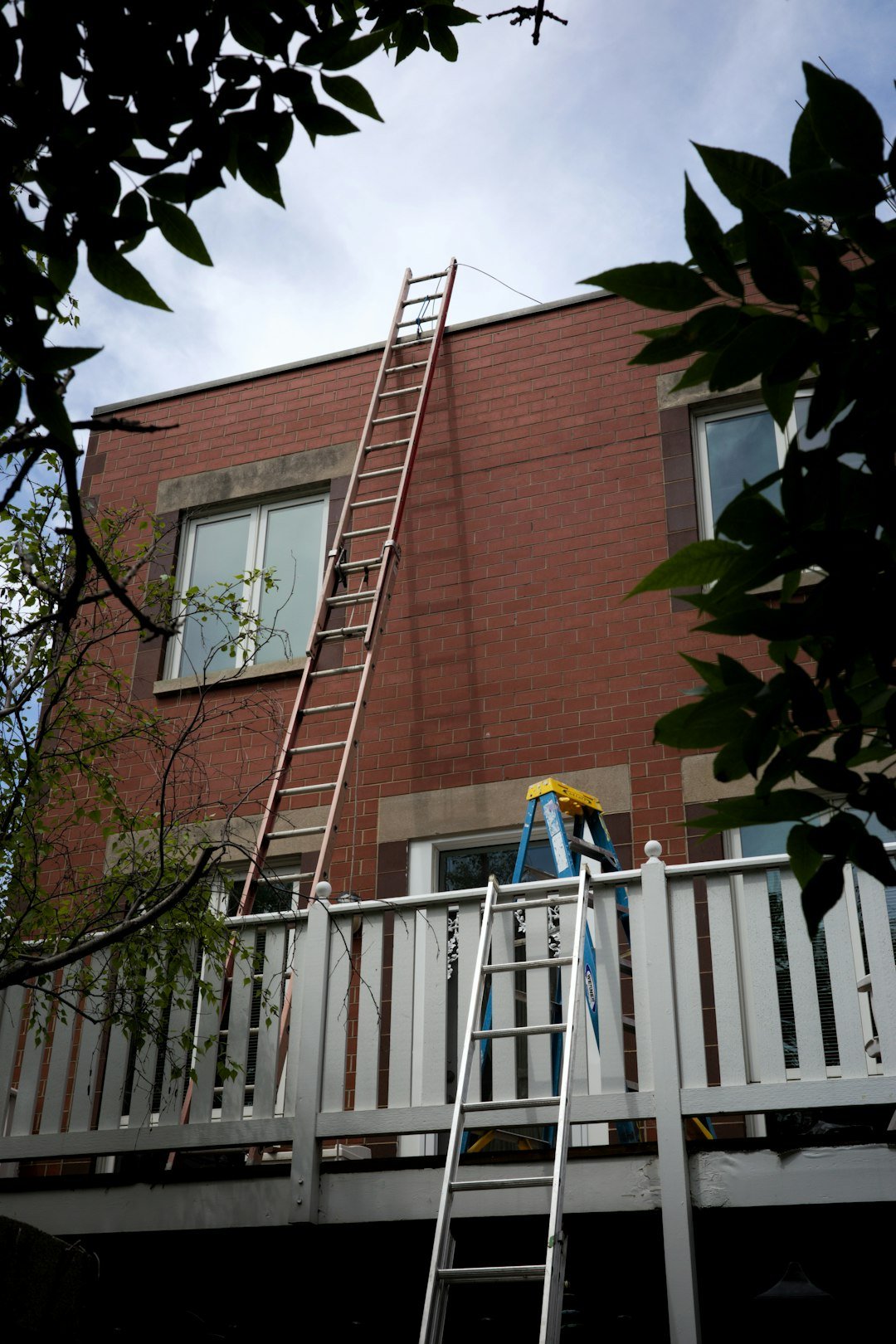 why-choose-us-01 ladders-leaning-against-a-brick-building-with-a-balcony-vyehcepesgs